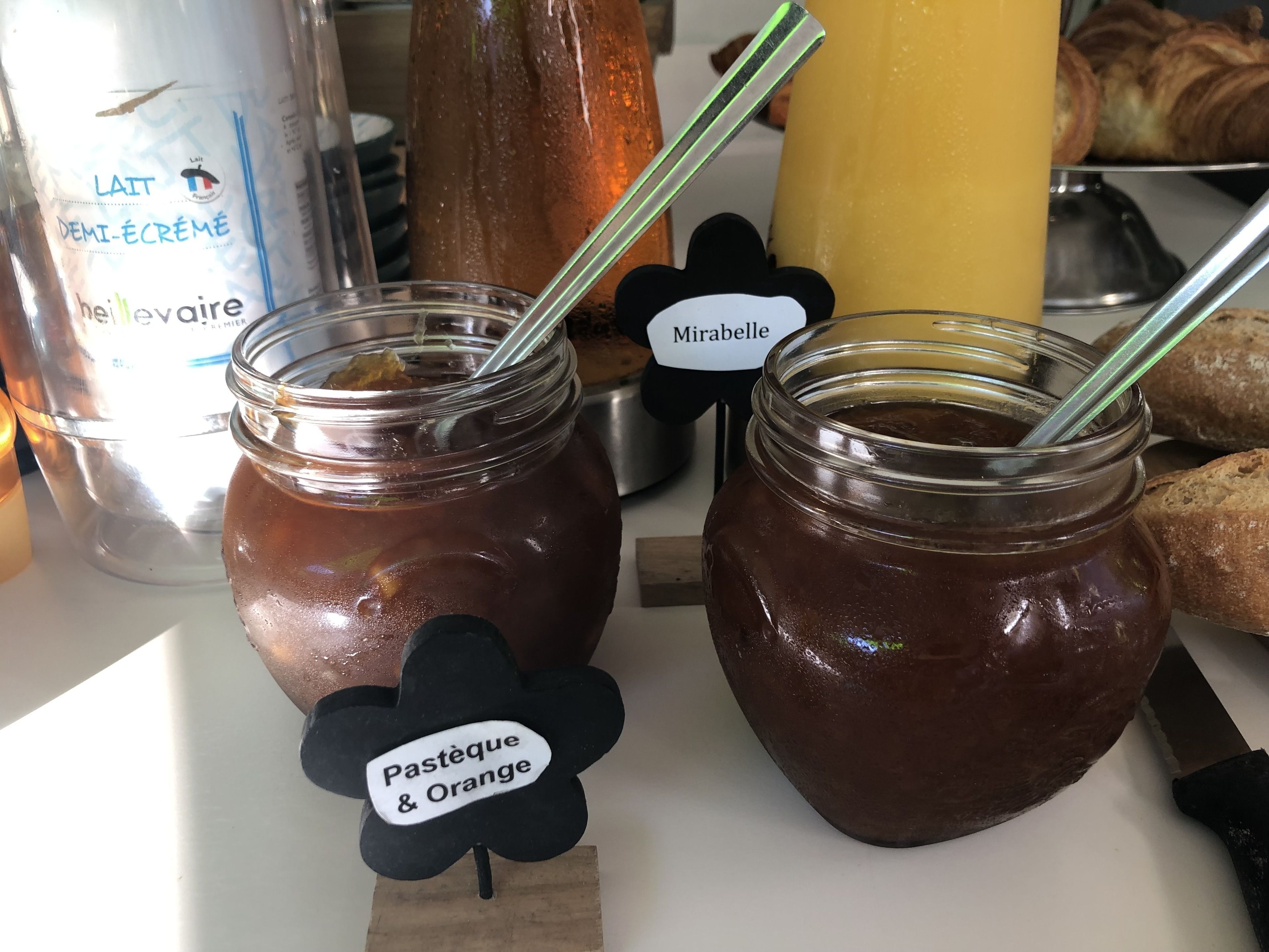 Dos tarros de mermelada con etiqueta 'Pasteque & Orange', adornada con un diseño floral negro.