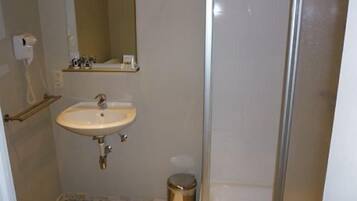 A small bathroom with a sink, mirror, and toilet.