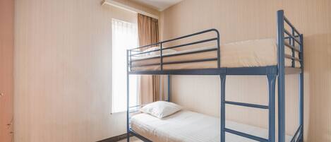Quarto com beliche, janela, cortinas e porta.