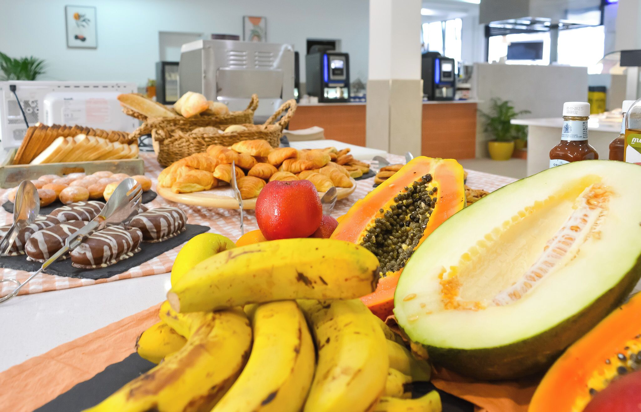A buffet with various fruits, pastries, and chocolate treats.