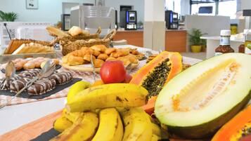 A buffet with various fruits, pastries, and chocolate treats.