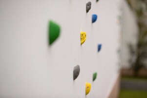 A wall with multiple climbing holds of different colors.