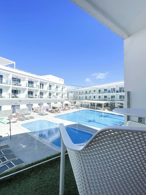 Ein Hotel mit Poolbereich, mehreren Balkonen und Blick auf den Pool.