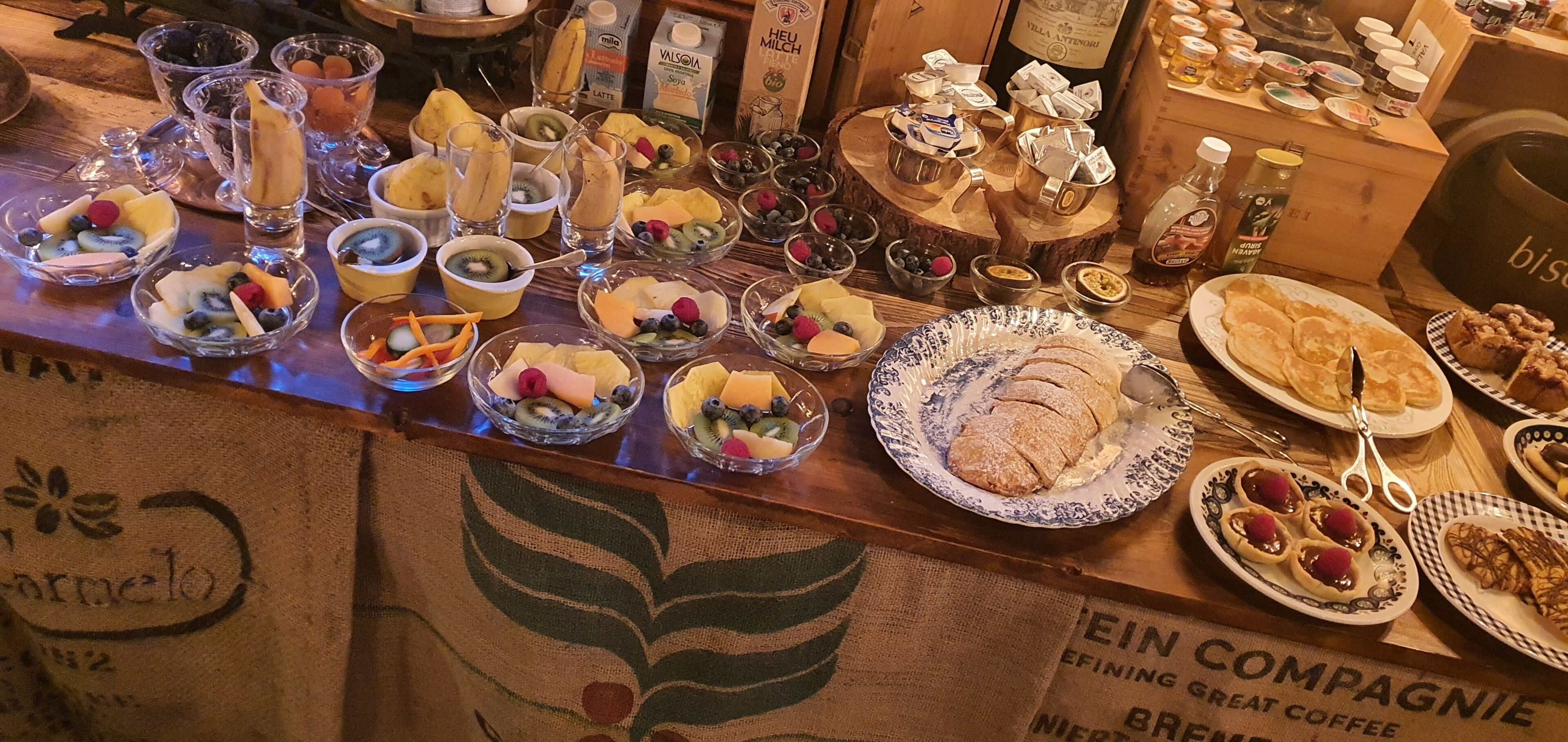 Ein reichhaltiges Frühstücksbuffet mit verschiedenen Früchten, Gebäck und Getränken.