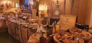 A buffet setup with various food items, beverages, and condiments. - Villa Martha Vintage Hotel B&B (Santa Cristina Val Gardena)