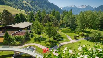 A mountain landscape with a bridge, pathways, and a building with a sloped roof.