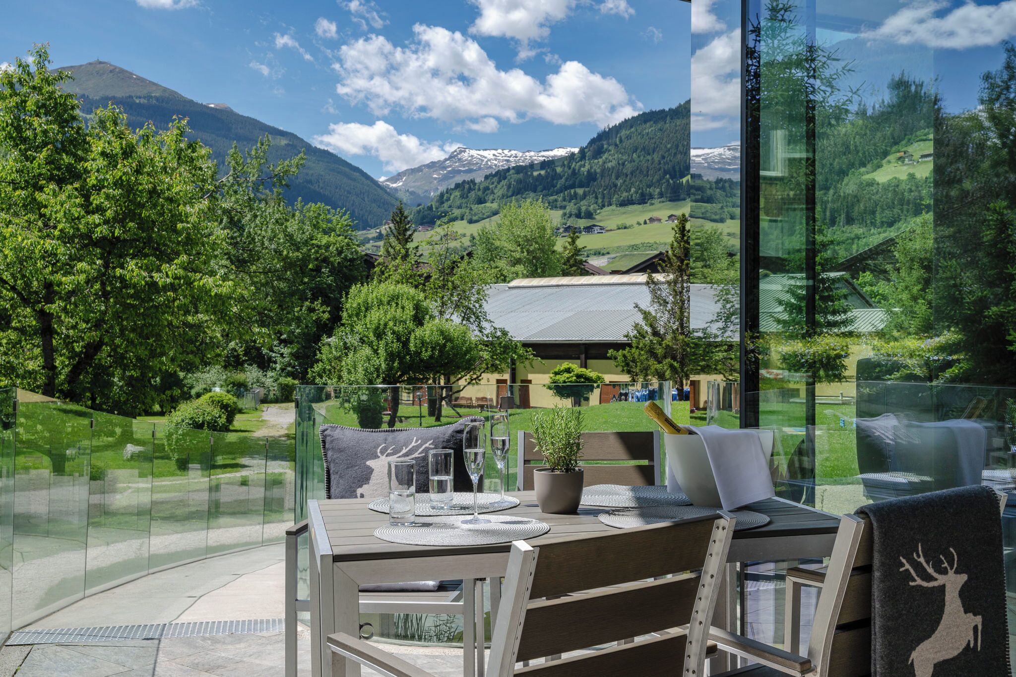 A dining area with a table set for two, overlooking a mountainous landscape.