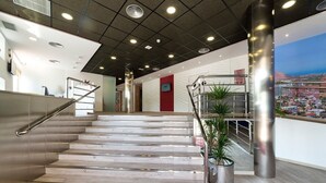 A modern interior with a staircase, metal railings, and a cityscape view. - Hotel Montemar Benidorm (Benidorm)