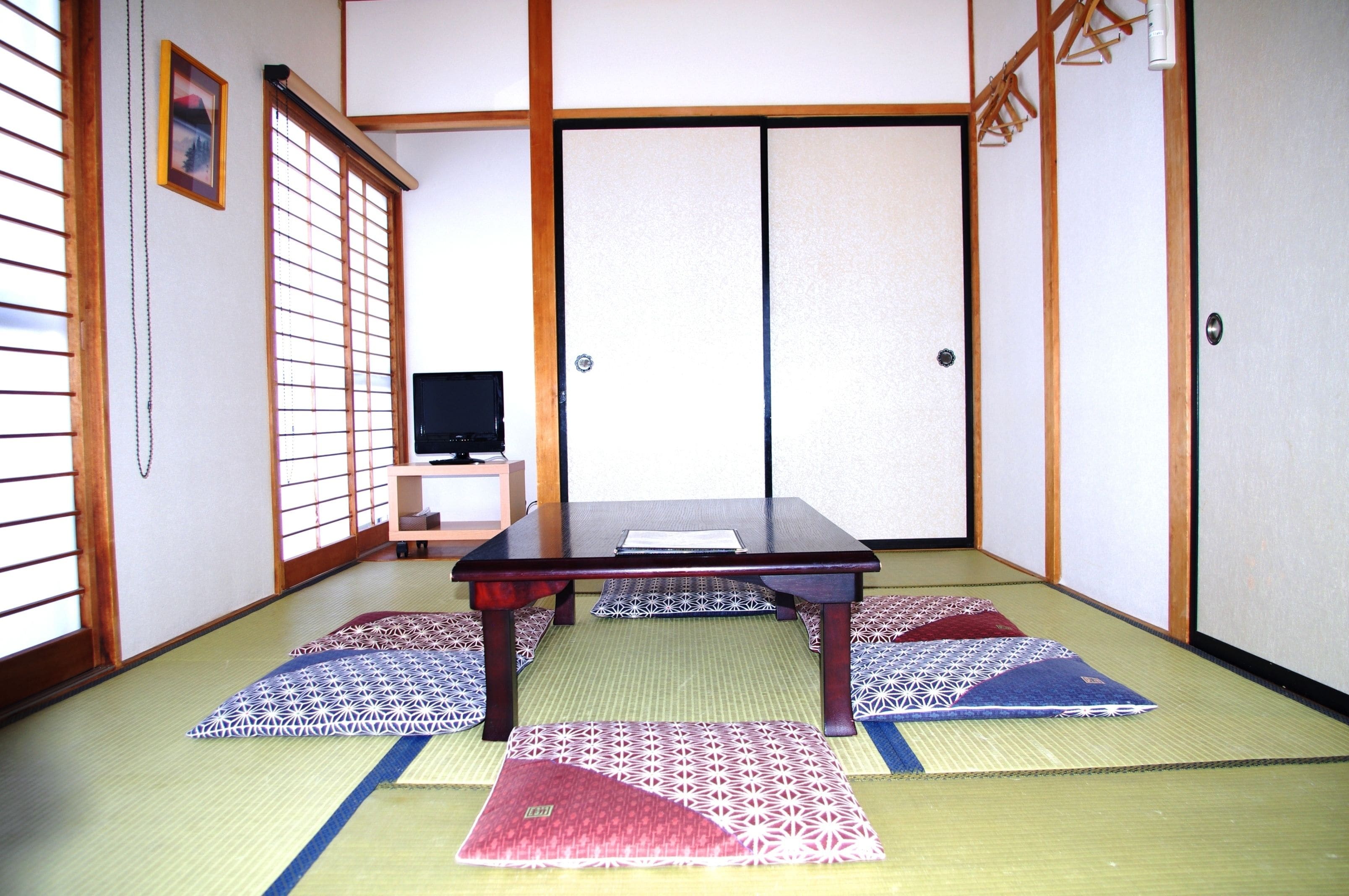 A traditional Japanese room with tatami flooring, a low wooden table, and shoji screens.