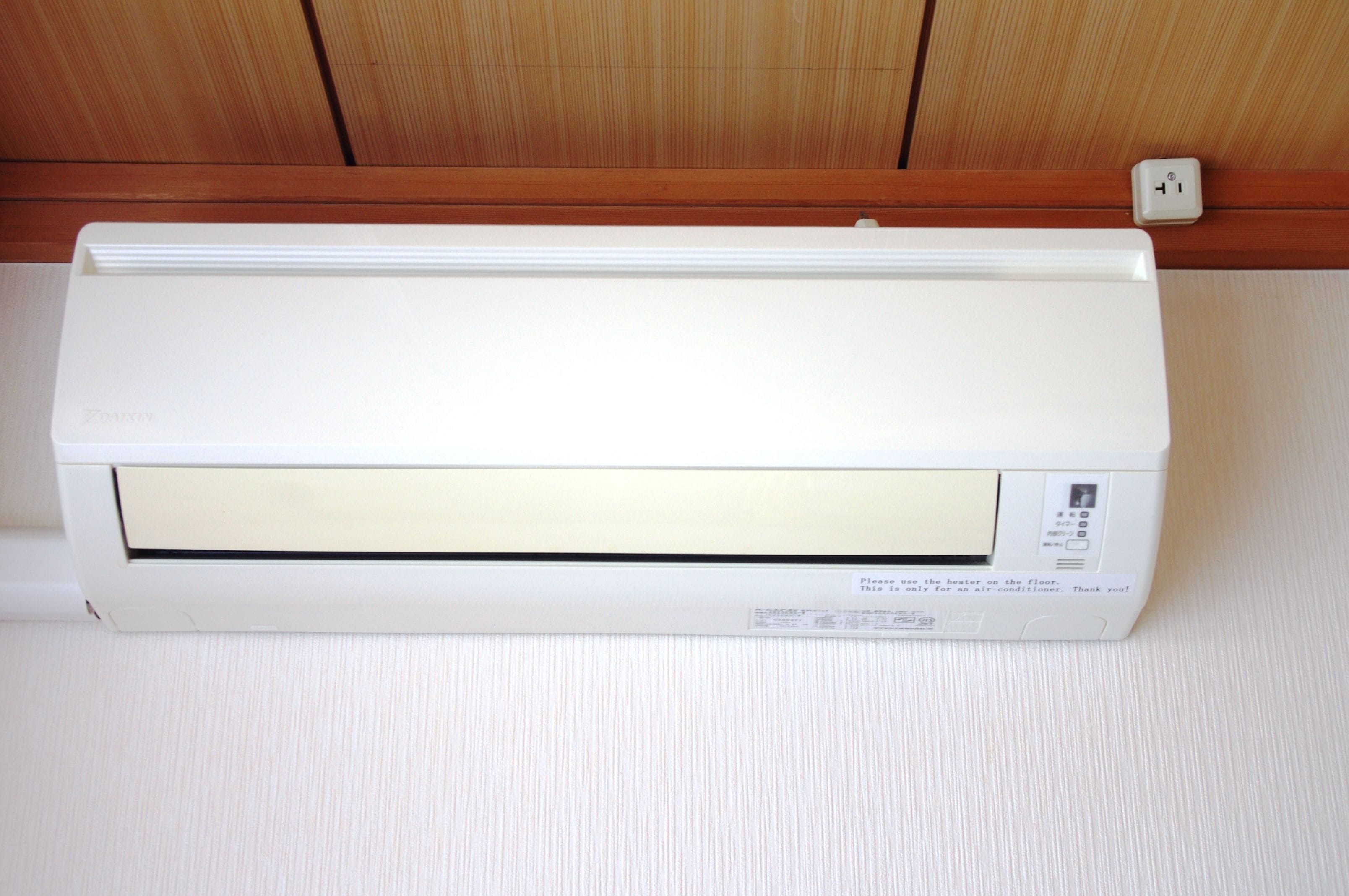 A white wall-mounted air conditioner with a control panel on the right side.