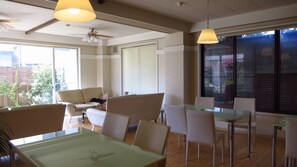 Um interior moderno com área de jantar, um sofá e um ventilador de teto.