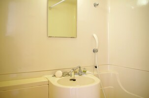 A bathroom with a sink, mirror, and shower.