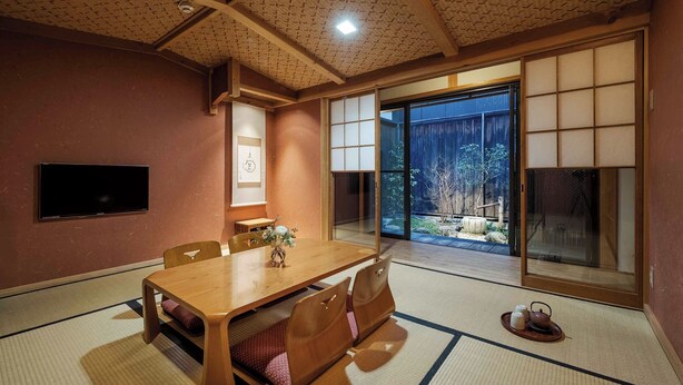 A traditional Japanese-style room with tatami flooring, a wooden dining table, and sliding shoji doors.