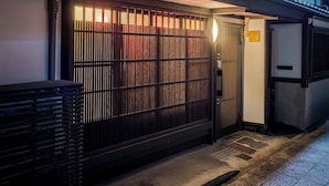 A traditional Japanese-style building with a wooden gate and a lit interior.
