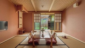 A traditional Japanese room with tatami flooring, a low wooden table, and shoji screens.