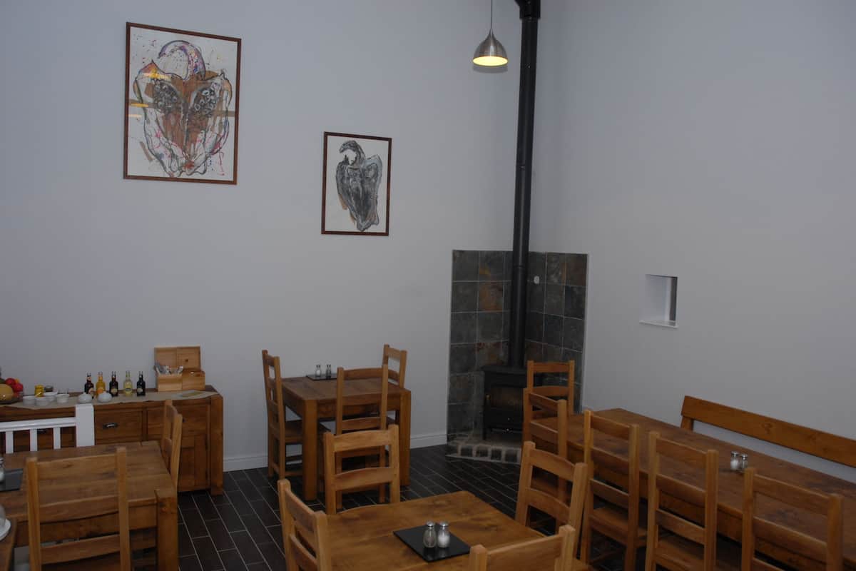 A dining area with wooden furniture, a fireplace, and artwork on the walls.