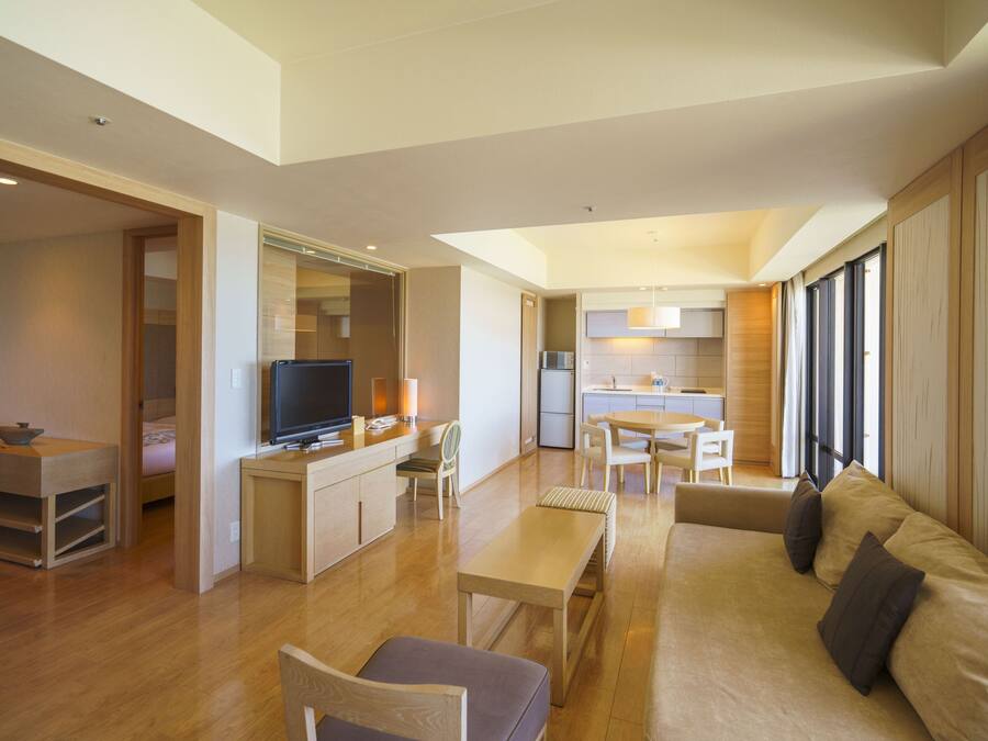 A modern living room with a sofa, a TV, and a dining area.