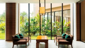 Una habitación con un amplio ventanal, dos sofás, una mesa y una lámpara colgante.