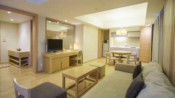A modern living room with a sofa, a coffee table, a TV, and a dining area with chairs and a table.