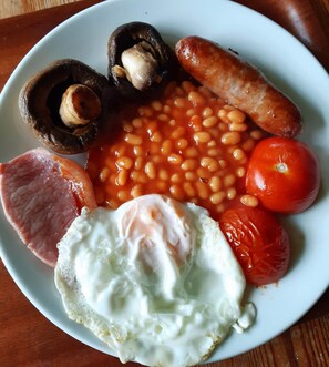 A plate of breakfast food including eggs, sausages, beans, tomatoes, and mushrooms. - Gallen-treath Guest House (Helston)