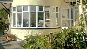A two-story house with large windows and a curved corner section. - Gallen-treath Guest House (Helston)