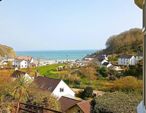 A coastal village with white houses, a view of the sea, and a green area in the foreground. - Gallen-treath Guest House (Helston)