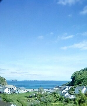 A coastal village with houses along the shore, a clear sky, and the sea in the background. - Gallen-treath Guest House (Helston)