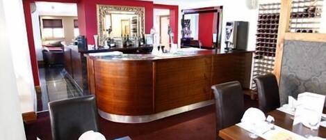 A restaurant with a wooden bar, dining tables, and chairs.