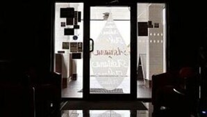 A hotel entrance with a glass door reflecting the interior. - Ashiana Hotel (Newark)