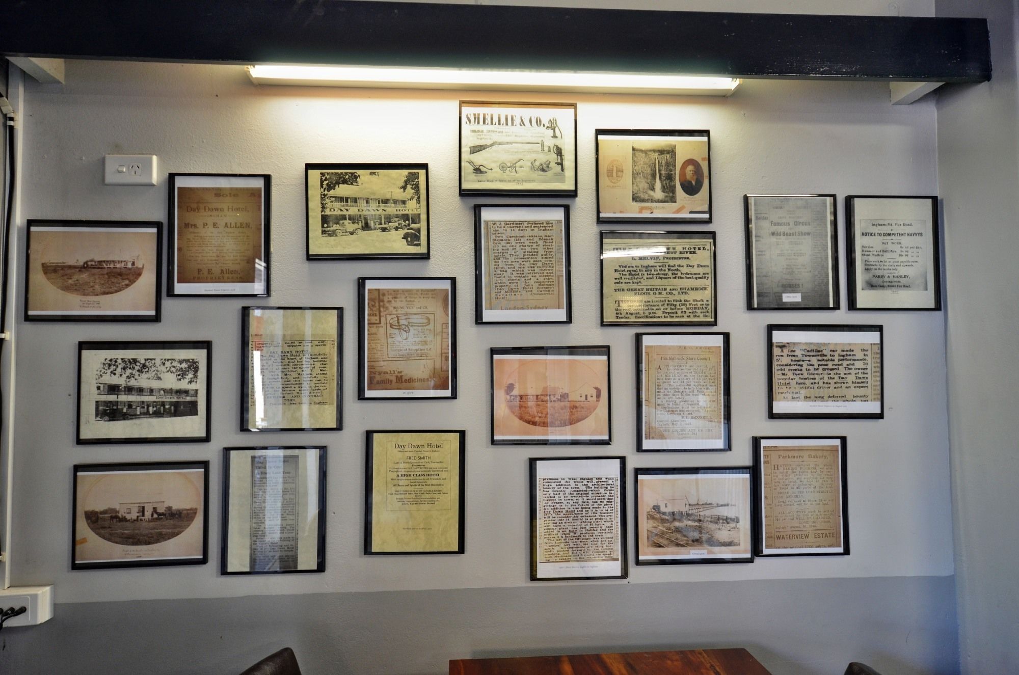 Paret amb diversos documents històrics i fotografies, incloent un menú emmarcat de l'Hotel Day Dawn i un mapa de Londres.