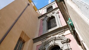 A narrow street with buildings featuring traditional architecture and a clear blue sky. - B&B Il Campanile (Naples)