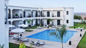 A modern hotel with a swimming pool, multiple balconies, and outdoor seating areas. - Villa Agapanthe (Fes)