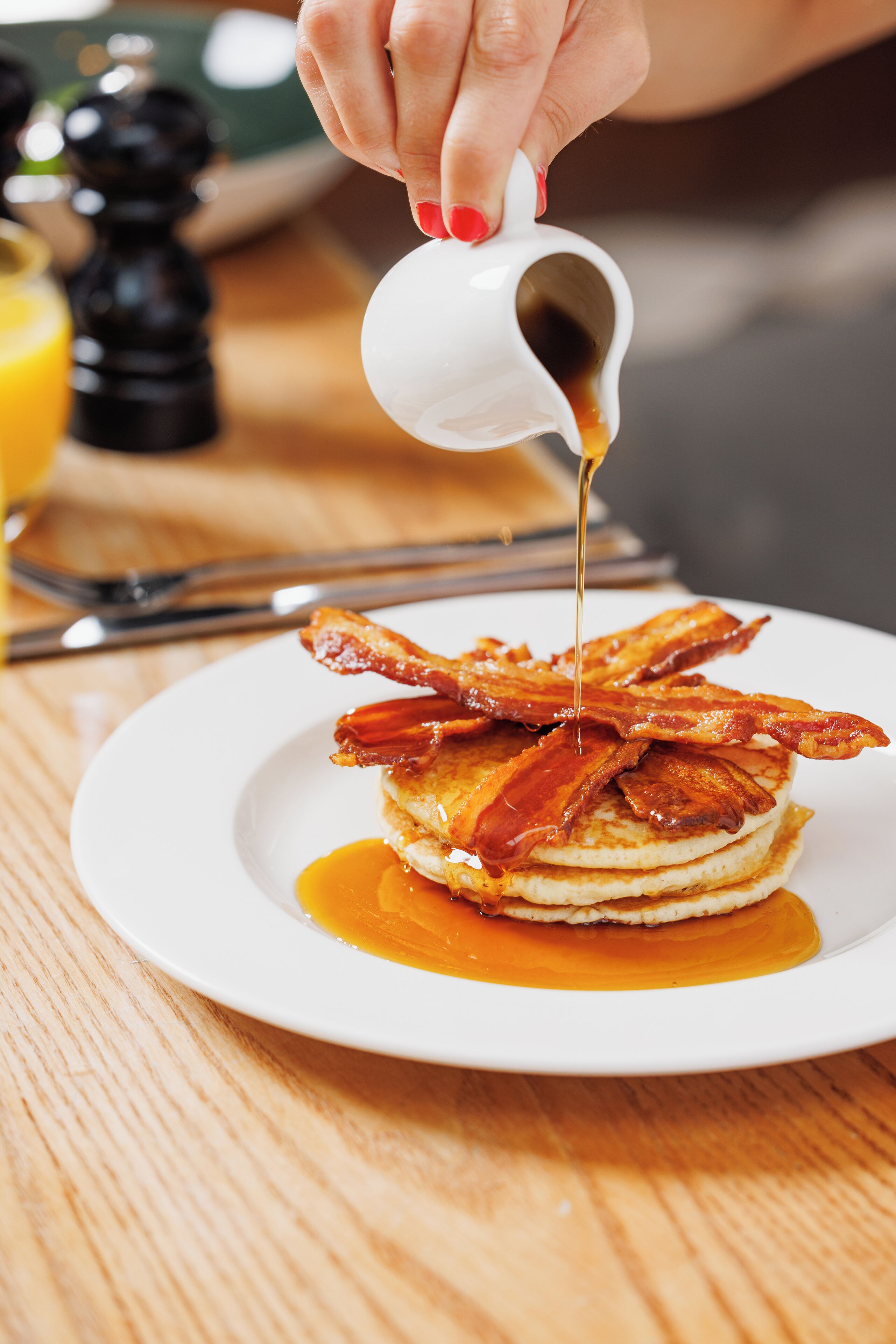 Une assiette de crêpes garnies de lardons et nappées de sirop.