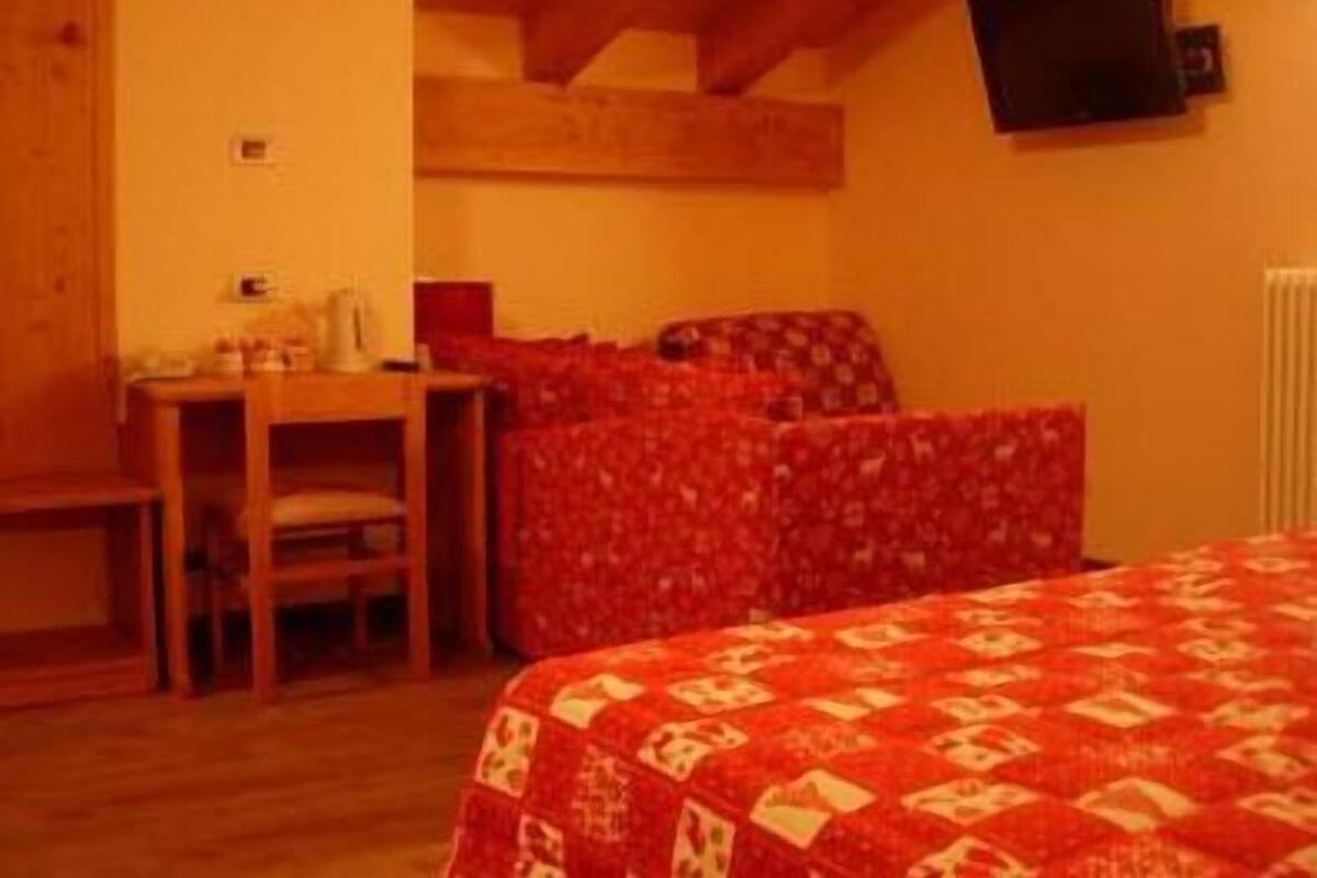 Una habitación acogedora con una cama, un escritorio y una silla.