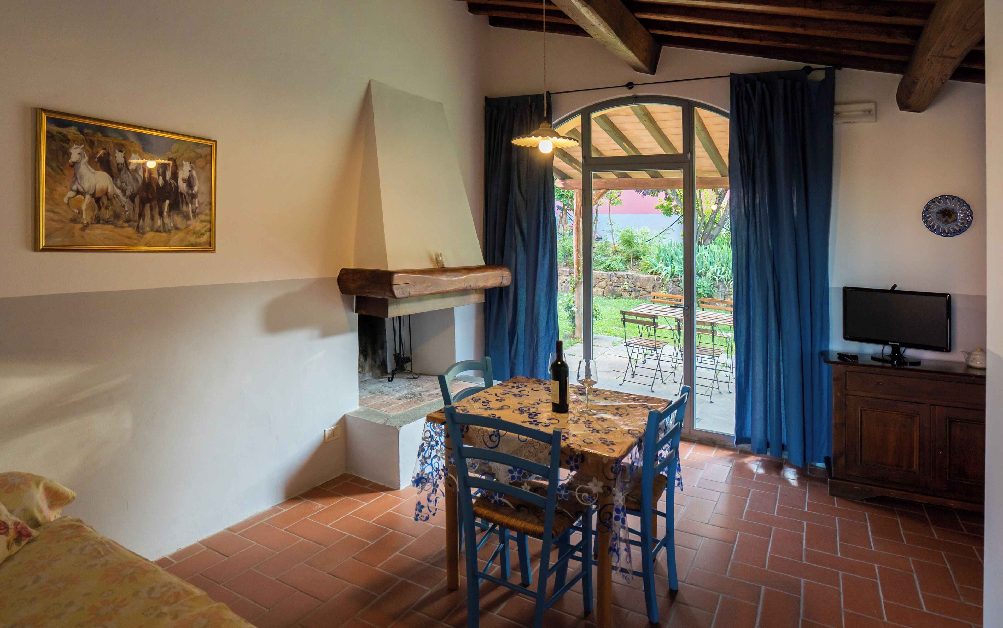 A dining area with a table, chairs, and a television.