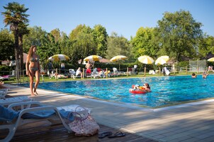 Una piscina al aire libre de temporada, sombrillas