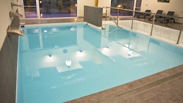 Una piscina techada, sillones reclinables de piscina