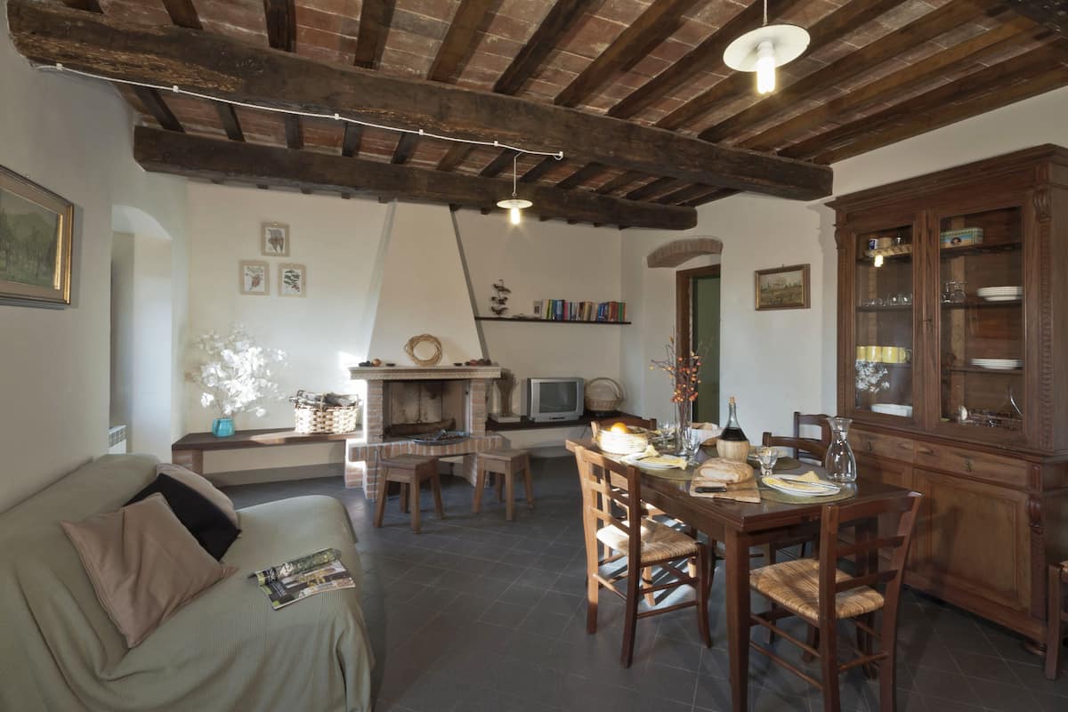 Ein gemütliches Wohnzimmer mit Kamin, Holzmöbeln und einem Fernseher.