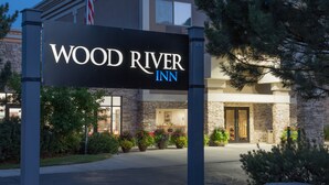 A hotel sign for Wood River Inn with a stone facade and a welcoming entrance. - Wood River Inn & Suites (Hailey)