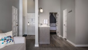 A modern interior with a central island sink, white doors, and a hallway leading to a bedroom. - Tamarack Lodge Sun Valley (Ketchum)