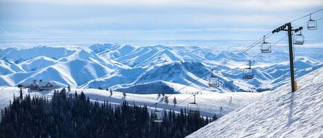 A snow-covered mountain landscape with ski lifts and a lodge.