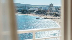 A coastal cityscape with a beach, buildings, and a clear sky.