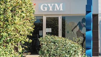A building with a sign reading 'GYM' and a glass door entrance.