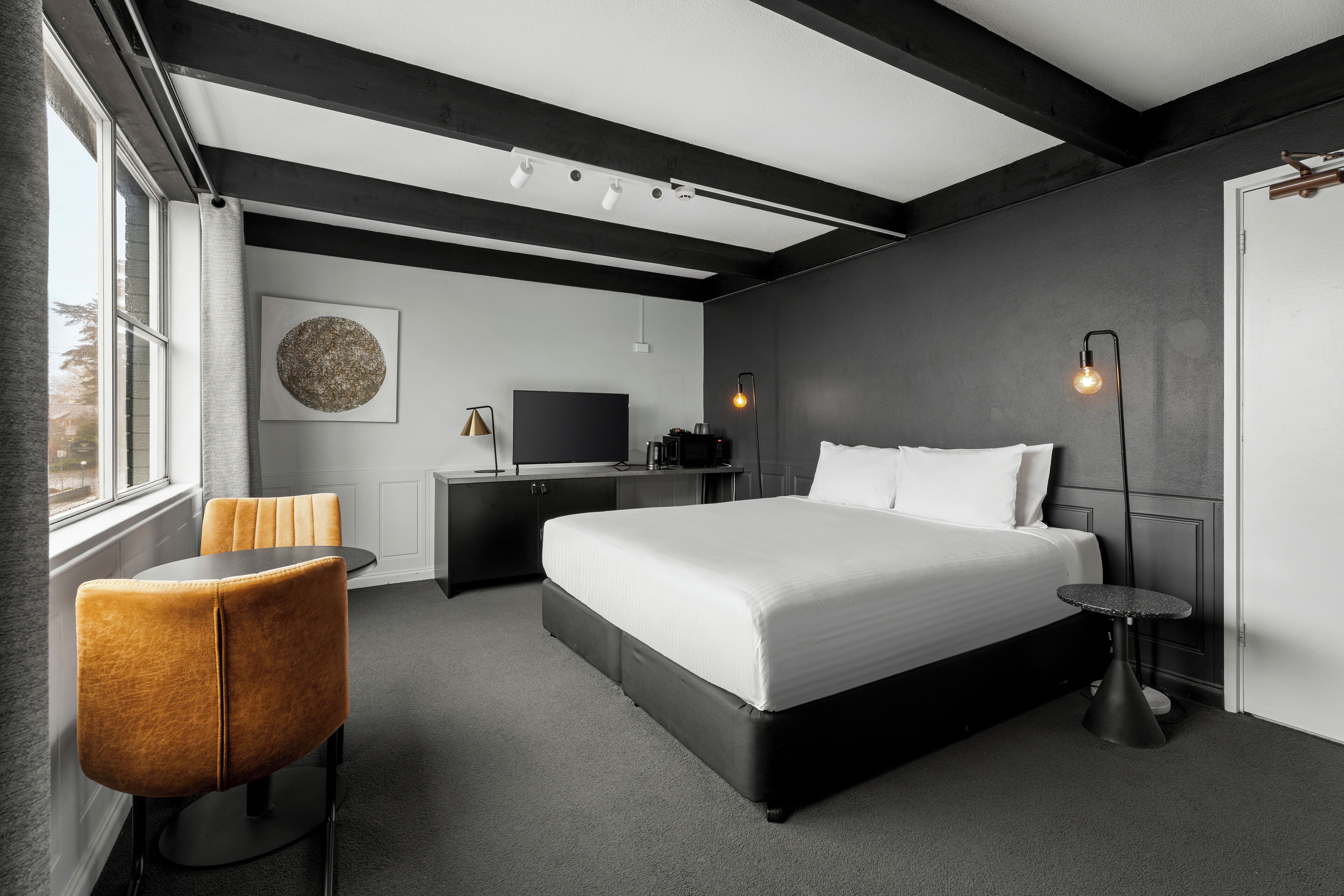 Une chambre à coucher moderne avec un grand lit, un bureau et une chaise.