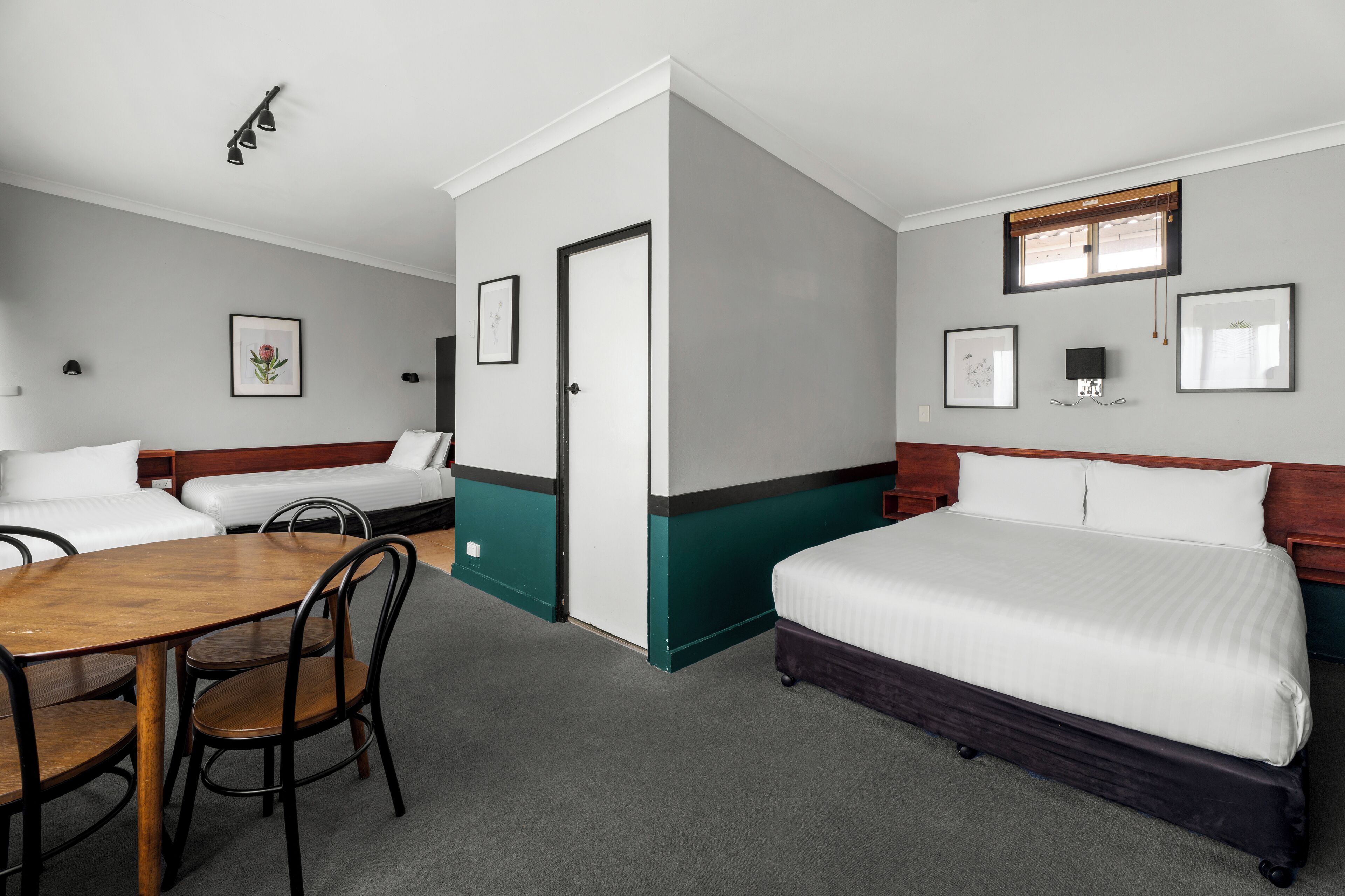 A hotel room with a bed, a desk, and two chairs.
