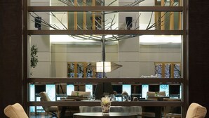 A modern interior with a glass partition, a dining table, and two chairs. - Esperos Palace Luxury & Spa Hotel (Kastoria)