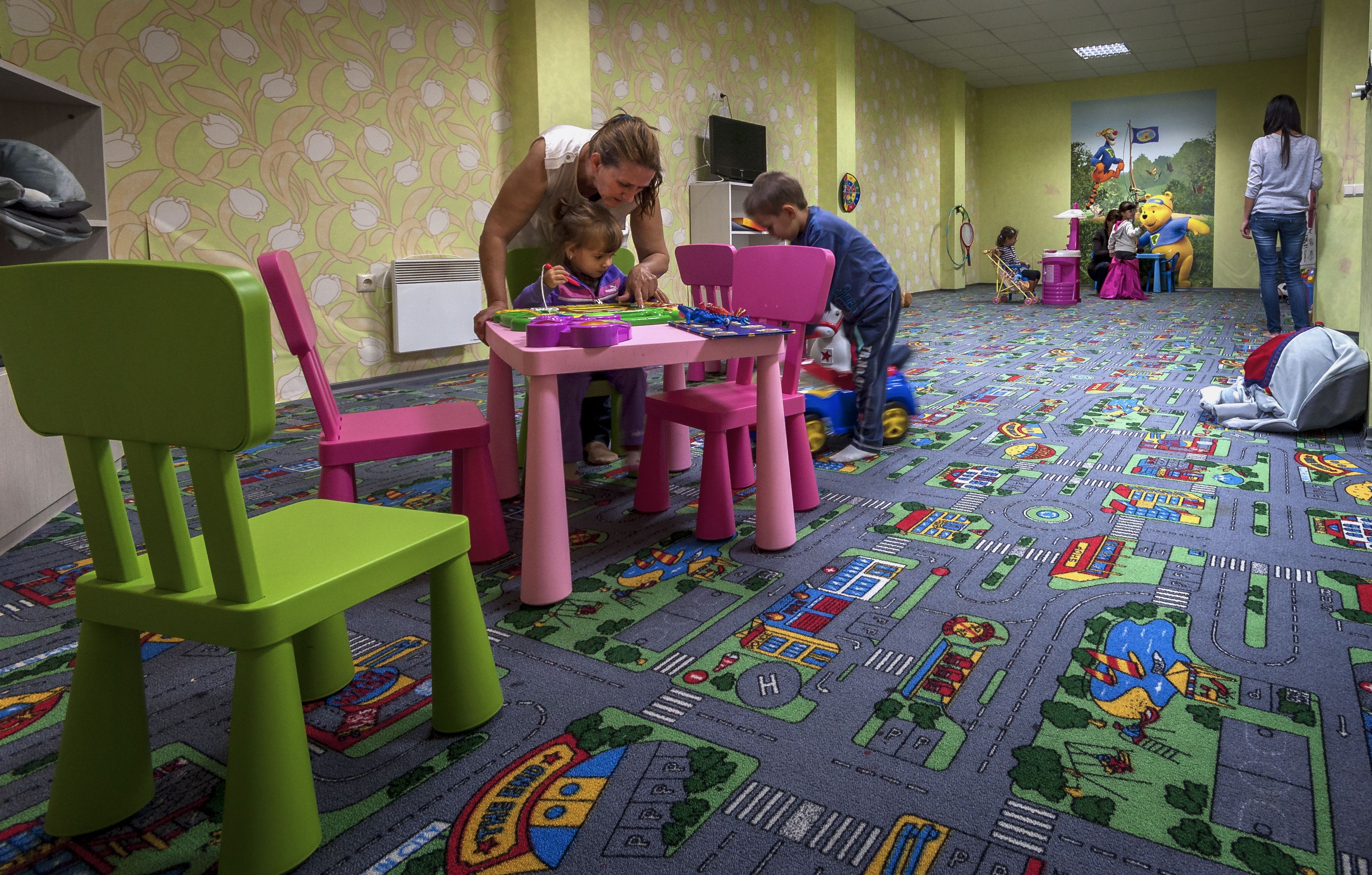 A room with colorful chairs and a carpet with a cityscape design.