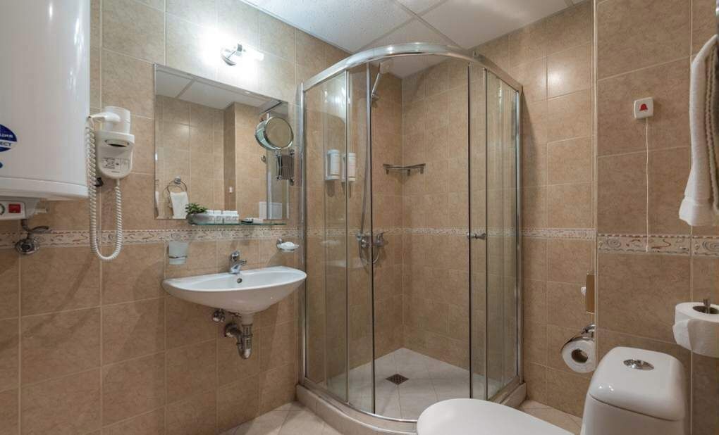 A modern bathroom with a glass-enclosed shower, a sink, and a toilet.