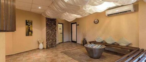 A reception area with a tiled floor, a reception desk, a wall clock, and a large decorative bowl.