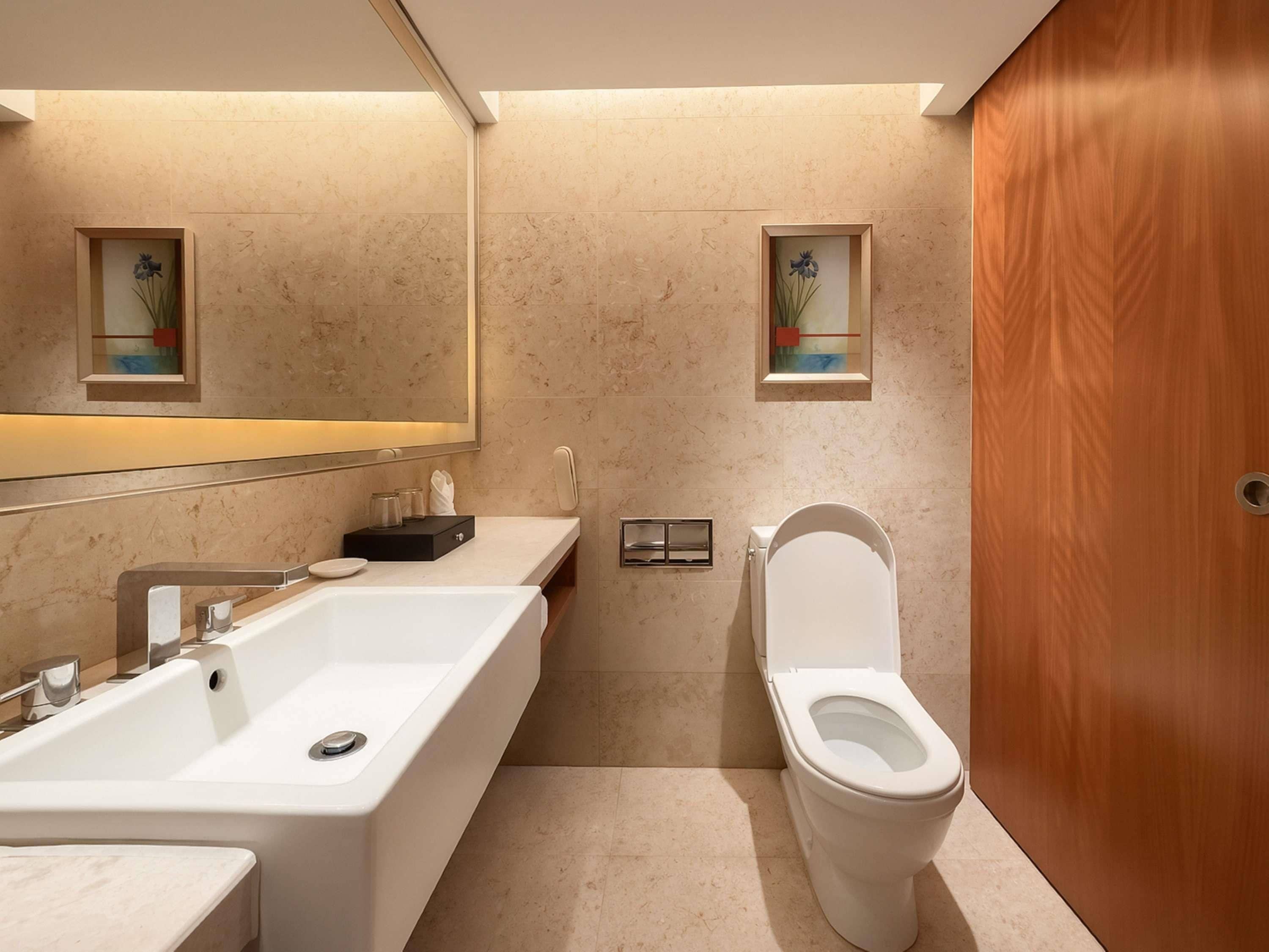 Un baño moderno con bañera, inodoro y puerta de madera.